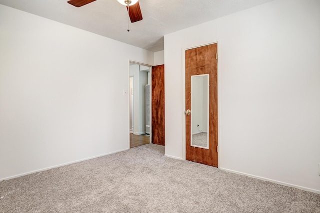 empty room with ceiling fan and light carpet