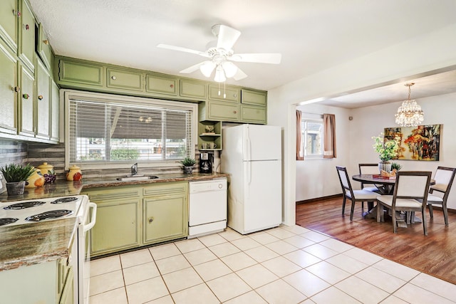 kitchen featuring green cabinets, light tile patterned flooring, sink, and white appliances