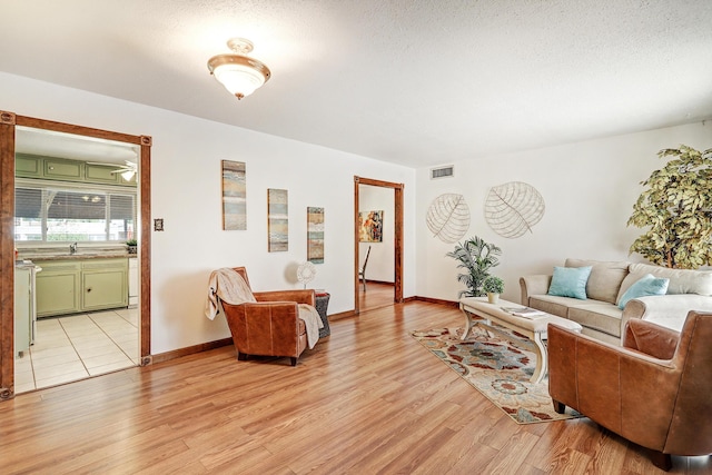 living room featuring a textured ceiling and light hardwood / wood-style flooring