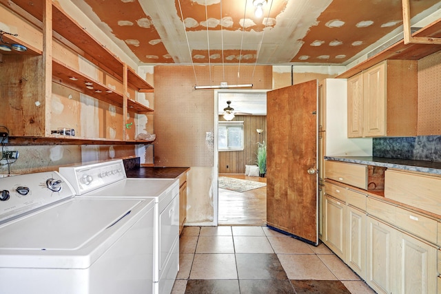 laundry area featuring washer and dryer, light tile patterned floors, wood walls, and ceiling fan