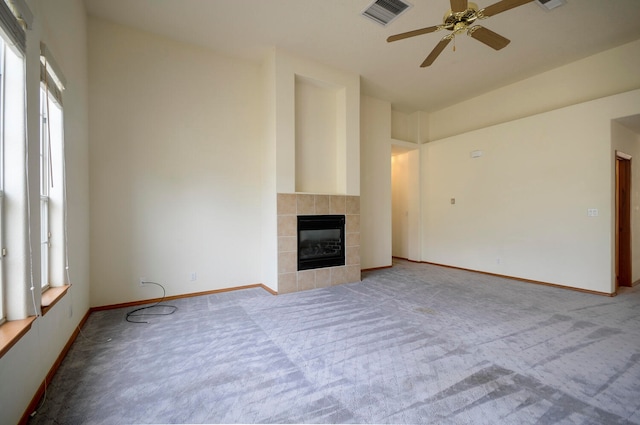 unfurnished living room featuring light colored carpet, a fireplace, and ceiling fan