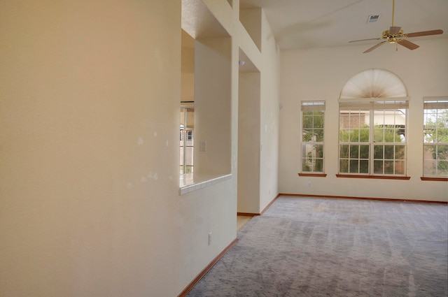 corridor featuring light colored carpet and high vaulted ceiling