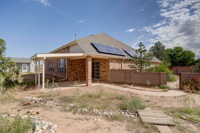 back of property featuring a patio and solar panels