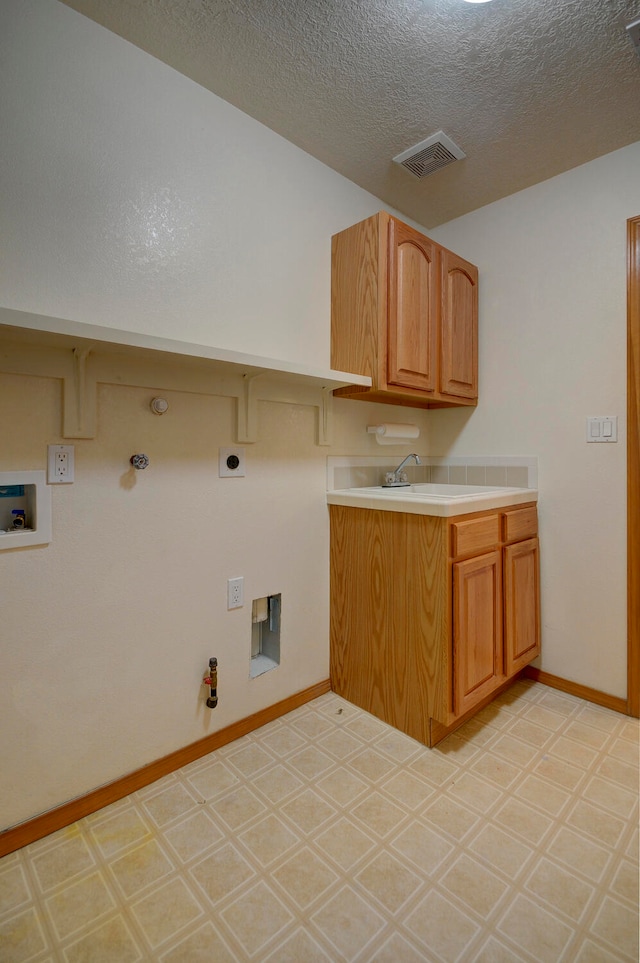 washroom with hookup for a washing machine, sink, a textured ceiling, gas dryer hookup, and electric dryer hookup