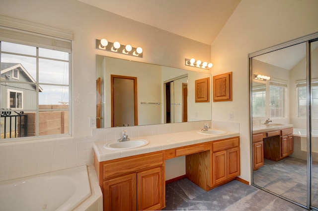 bathroom with vanity, lofted ceiling, and a relaxing tiled tub