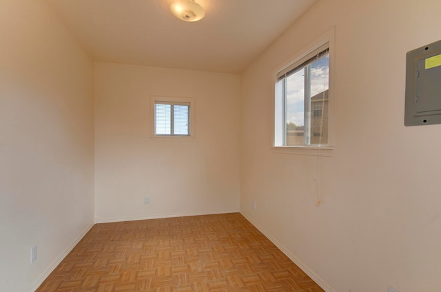 unfurnished room with electric panel and light parquet flooring