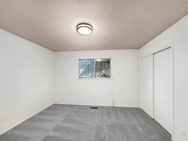 unfurnished bedroom featuring a closet, carpet, and a textured ceiling