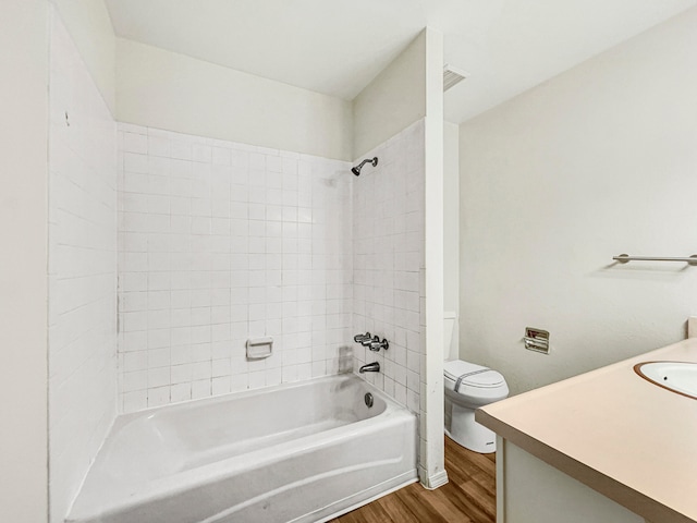 full bathroom with toilet, wood-type flooring, vanity, and tiled shower / bath combo