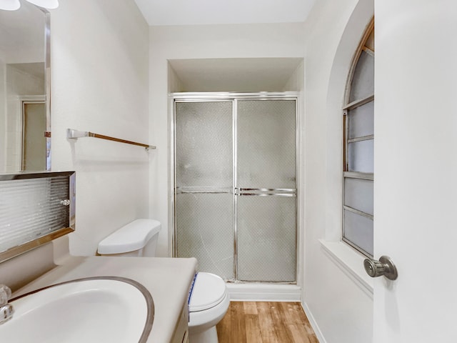 bathroom featuring hardwood / wood-style floors, vanity, an enclosed shower, and toilet