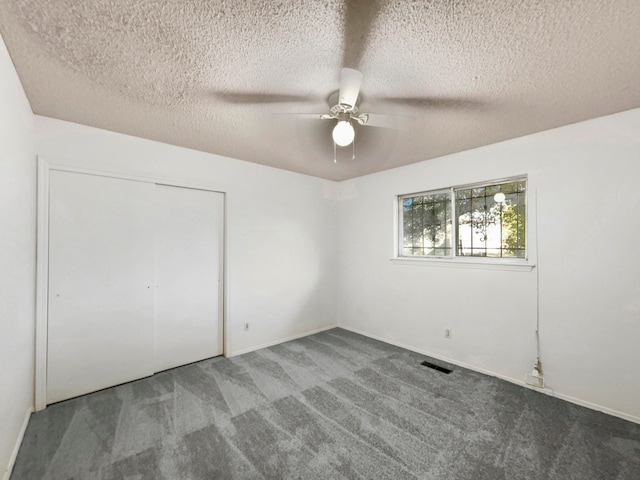 unfurnished bedroom featuring a closet, a textured ceiling, carpet floors, and ceiling fan