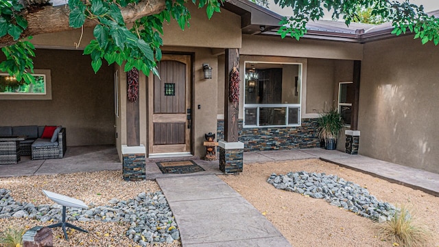 property entrance with outdoor lounge area and a patio