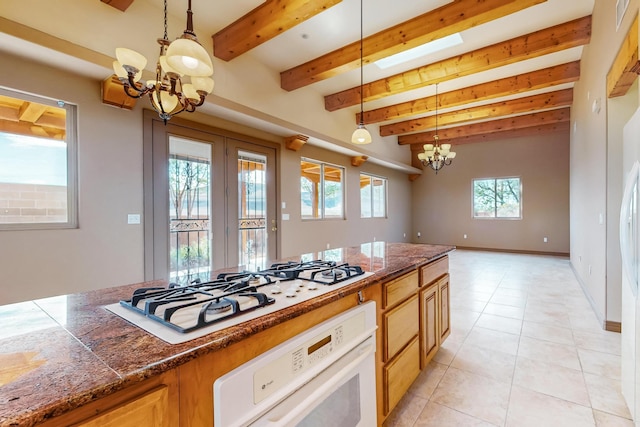 kitchen featuring beam ceiling, white appliances, hanging light fixtures, and a notable chandelier