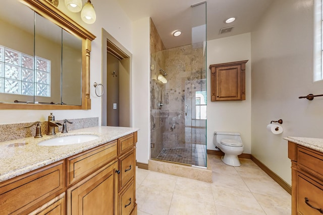 bathroom with tile patterned floors, a shower with door, vanity, and toilet