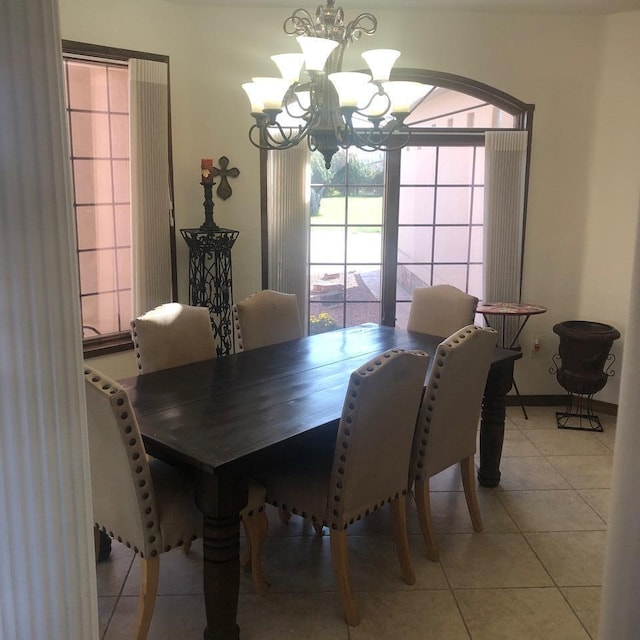 tiled dining area featuring an inviting chandelier