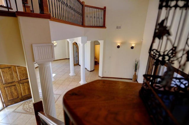 dining space featuring a high ceiling and ornate columns