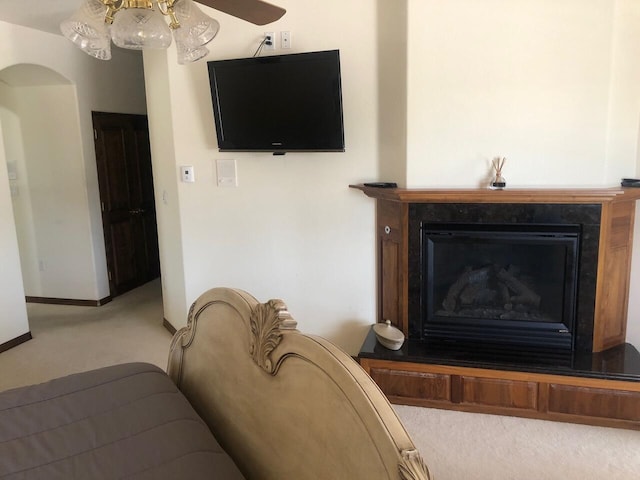 280 Angel Rd, Corrales, NM 87048 - living room with light carpet, a fireplace with raised hearth, arched walkways, and a ceiling fan