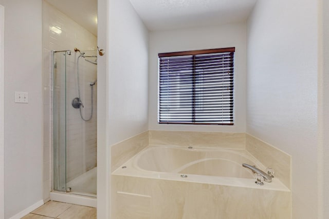 bathroom with independent shower and bath and tile patterned flooring