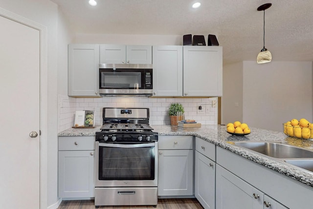 kitchen featuring white cabinets, appliances with stainless steel finishes, and decorative backsplash