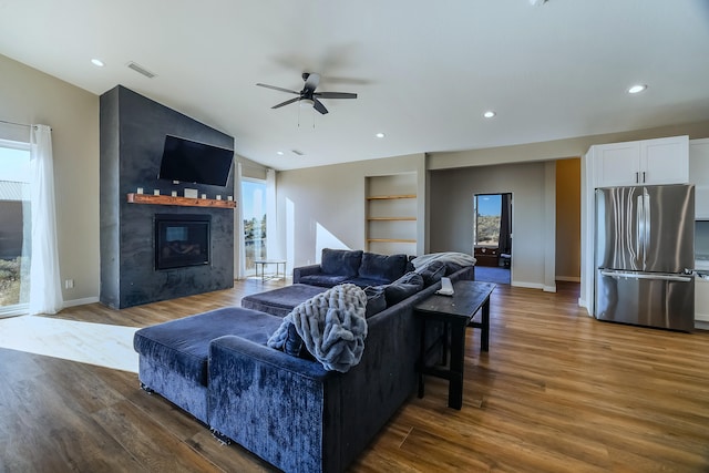 living room with lofted ceiling, ceiling fan, a fireplace, and dark wood-type flooring