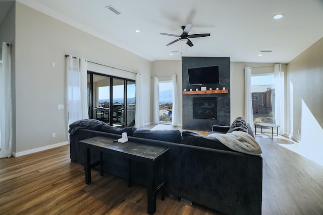 living room featuring vaulted ceiling, ceiling fan, dark hardwood / wood-style floors, and a fireplace