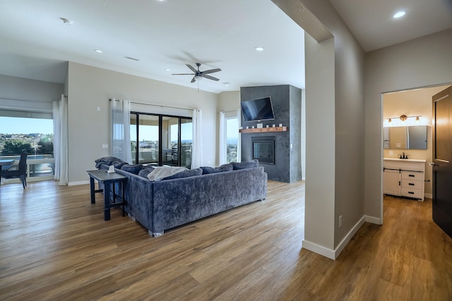 living room featuring wood-type flooring, ceiling fan, and a wealth of natural light