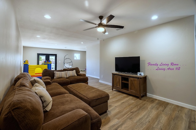 living room featuring ceiling fan and light wood-type flooring