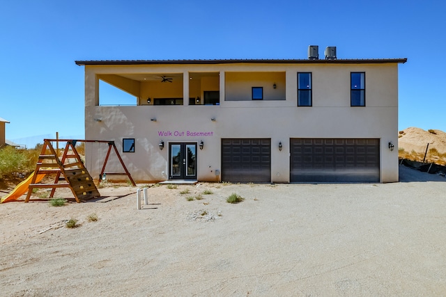 view of front of house with ceiling fan, french doors, and a garage