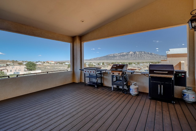 wooden deck with a mountain view and a grill