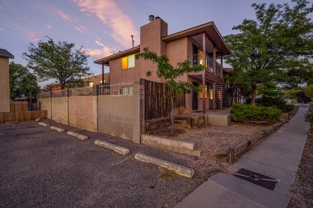 property exterior at dusk featuring a balcony