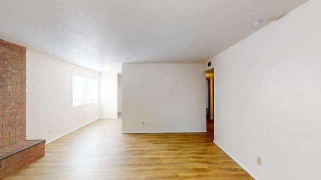 spare room with hardwood / wood-style flooring and a textured ceiling