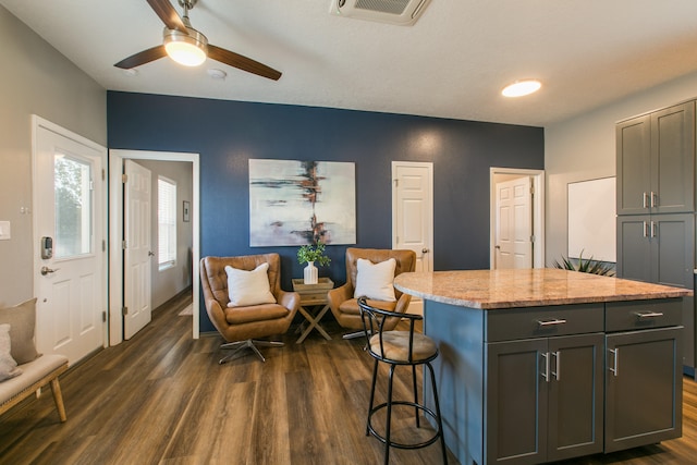 kitchen featuring ceiling fan, gray cabinets, dark hardwood / wood-style floors, and a kitchen island