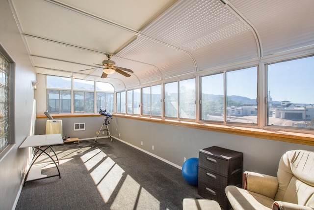 sunroom / solarium featuring a mountain view and ceiling fan