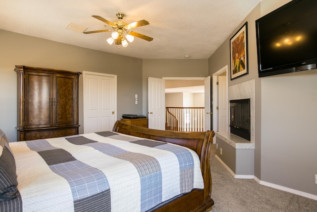 bedroom with ceiling fan, carpet floors, and a textured ceiling