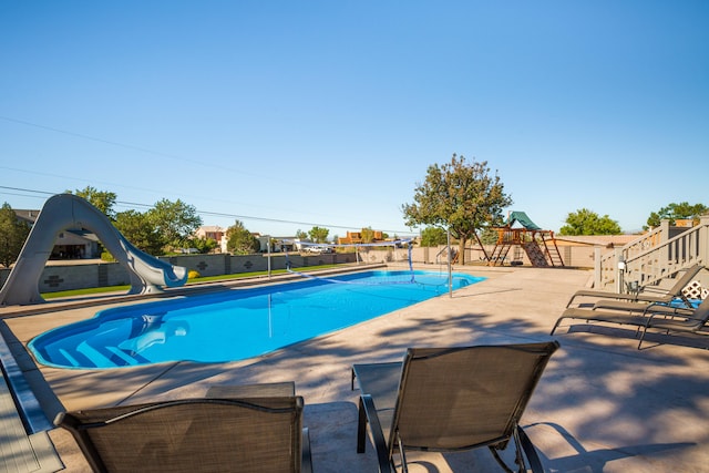 view of swimming pool with a patio and a water slide