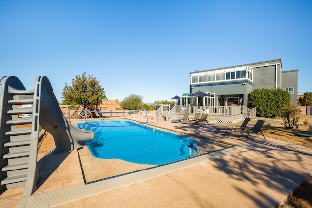 view of pool with a patio, a deck, and a water slide