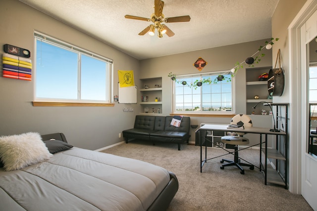 carpeted bedroom with ceiling fan and a textured ceiling