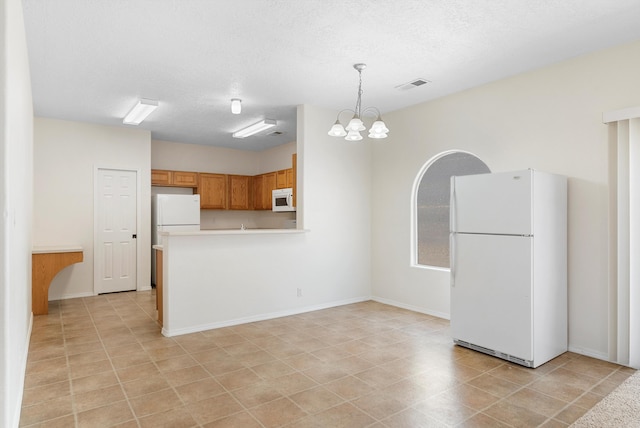 kitchen with a textured ceiling, kitchen peninsula, hanging light fixtures, an inviting chandelier, and white appliances