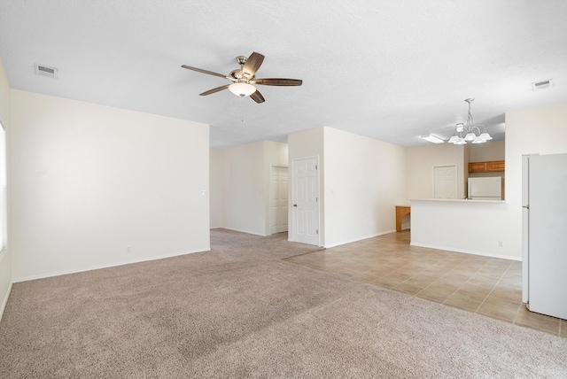 unfurnished living room with light carpet, a textured ceiling, and ceiling fan with notable chandelier