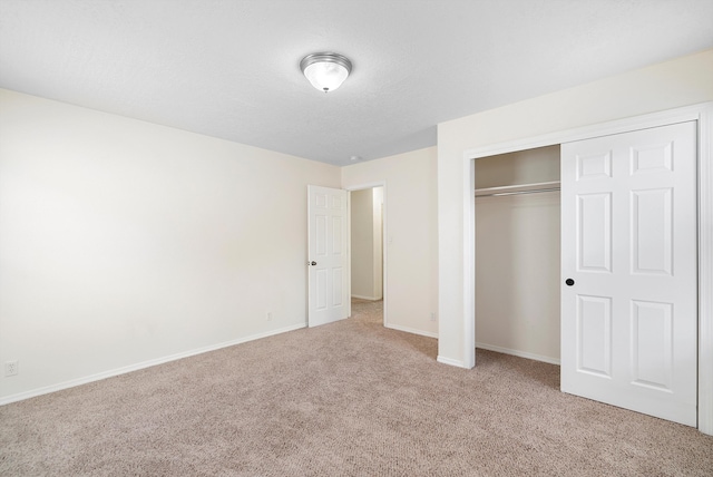 unfurnished bedroom featuring light colored carpet and a closet