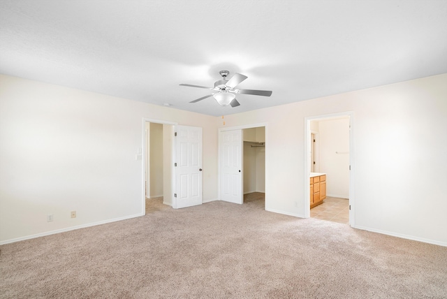 unfurnished bedroom featuring connected bathroom, ceiling fan, and light colored carpet