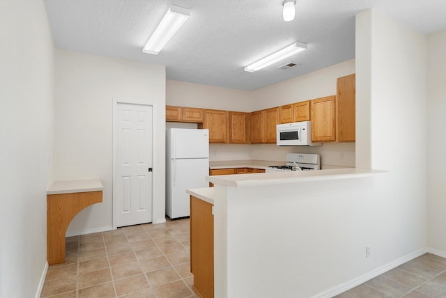 kitchen with kitchen peninsula, white appliances, a textured ceiling, and light tile patterned floors