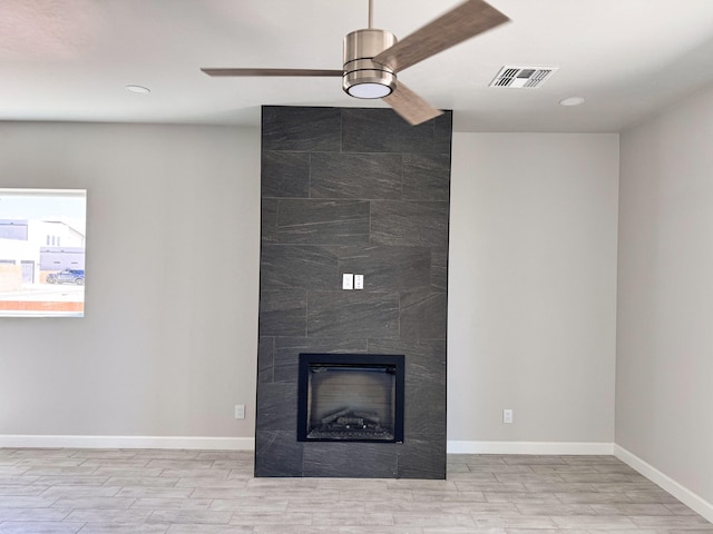 interior space with wood-type flooring, a fireplace, and ceiling fan