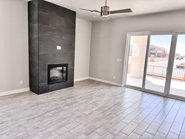 unfurnished living room featuring a large fireplace, ceiling fan, and light hardwood / wood-style flooring