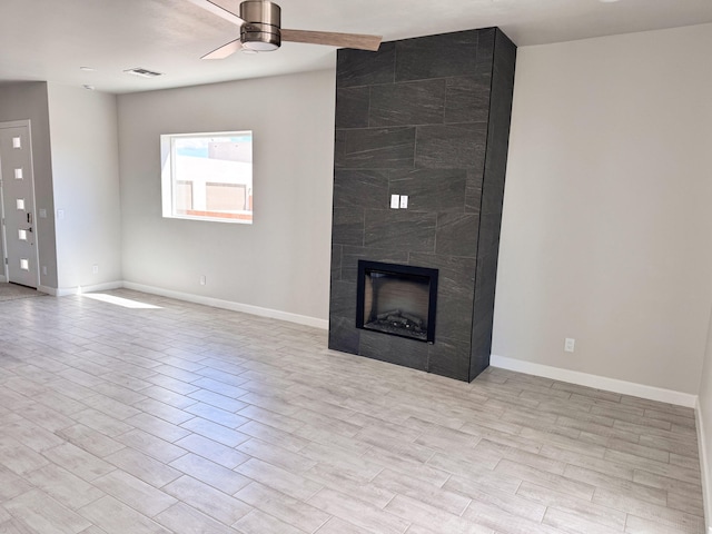 unfurnished living room featuring ceiling fan, light hardwood / wood-style flooring, and a tiled fireplace