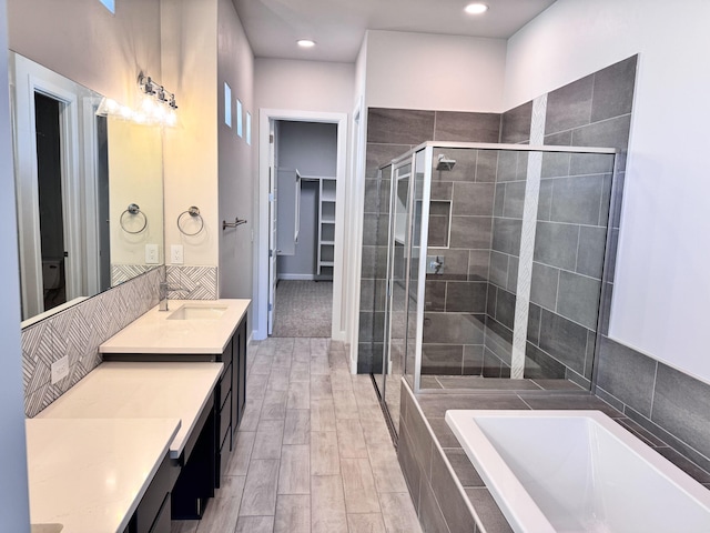 bathroom featuring wood-type flooring, vanity, and shower with separate bathtub