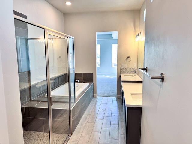 bathroom with shower with separate bathtub and vanity