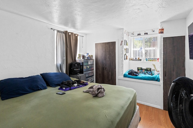 bedroom with a textured ceiling and hardwood / wood-style flooring