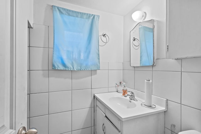 bathroom featuring tile walls, backsplash, and vanity