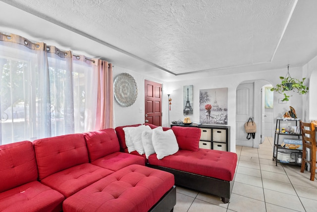 tiled living room featuring a textured ceiling