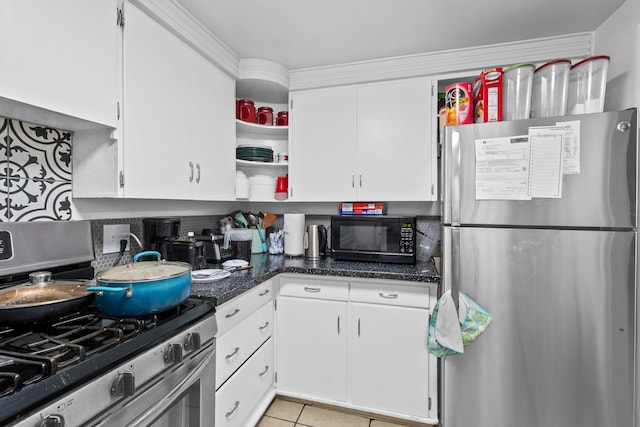 kitchen with white cabinets, light tile patterned flooring, stainless steel appliances, dark stone countertops, and decorative backsplash